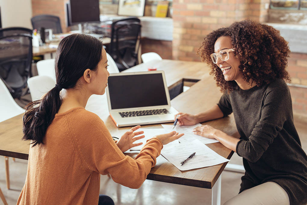 Two women discussing financial strategy.