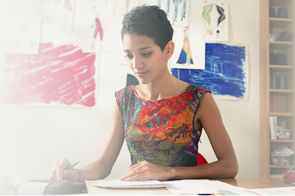 Photo of a woman using a printing calculator.